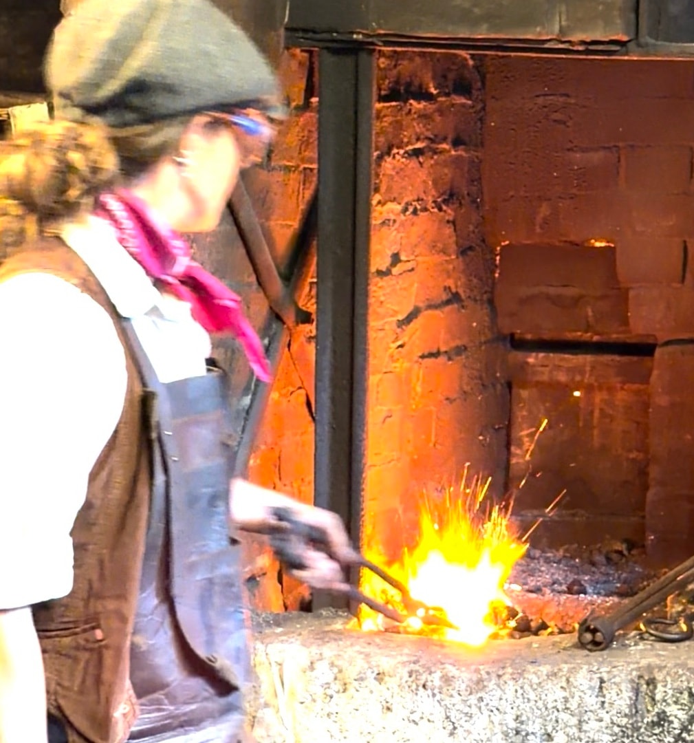 A smith working metal at the forge fire, Tooley's Boatyard, central Banbury